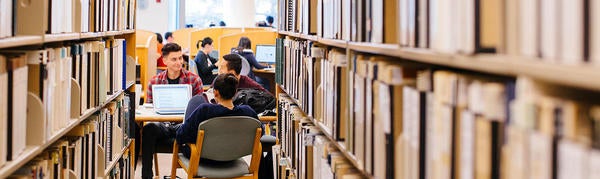 students in library at the end of bookshelves (c) UCR / CNAS